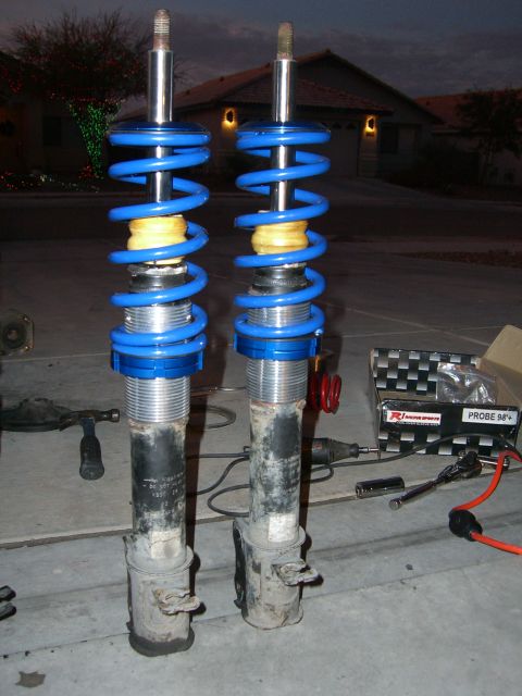 1996 Ford Probe - Two aftermarket coilover suspension struts are laid out on a concrete surface, with a box indicating compatibility with a 1994+ Probe.