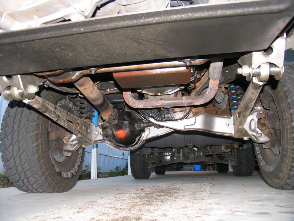Undercarriage view of a 4x4 vehicle with visible suspension and drivetrain components