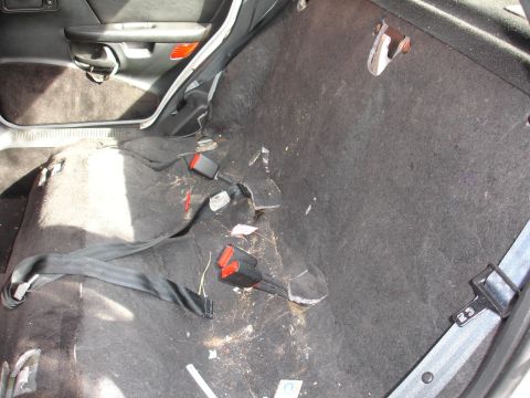 1993 Ford Taurus - Interior view of a car with rear seats removed, revealing the carpet and seatbelt mechanisms.