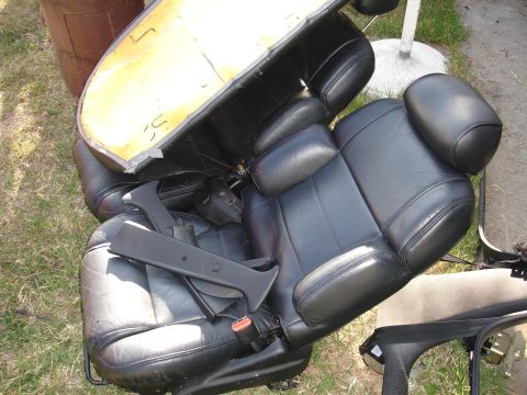 1993 Ford Taurus - Black leather car seats, likely removed from a vehicle, are shown outdoors with visible foam backing.