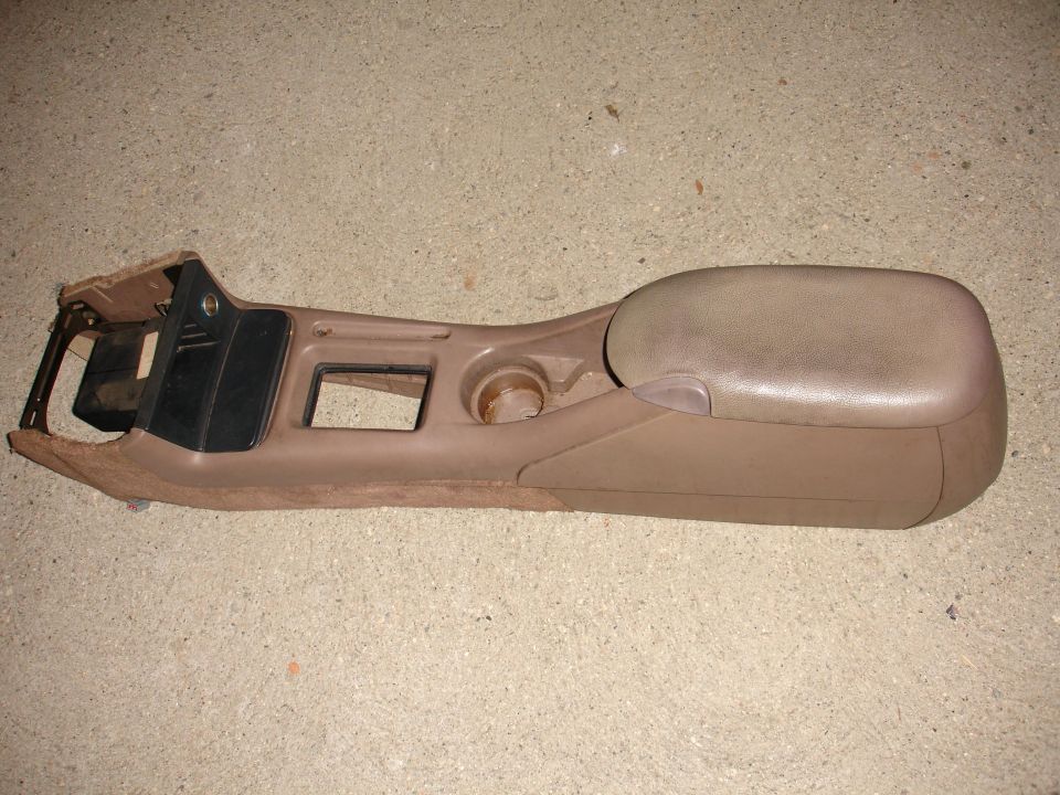 Brown center console with armrest and cupholder