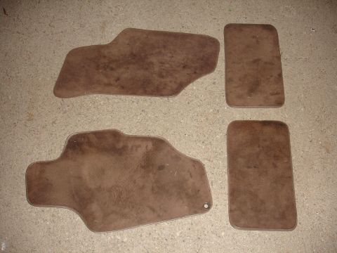 1993 Ford Taurus - Set of four used car floor mats, brown color, laid out on a floor.