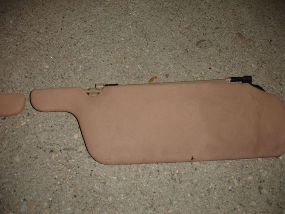 Tan car sun visor with black clip mechanism