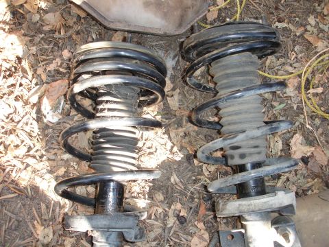1992 Ford Taurus - Two car suspension struts with coil springs are shown on the ground.