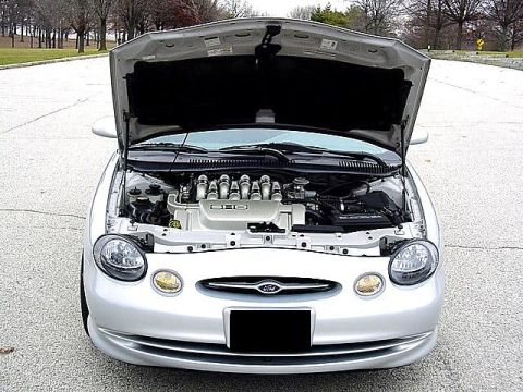 1998 Ford Taurus - The engine bay of a 1998 Ford Taurus is visible with the hood raised.