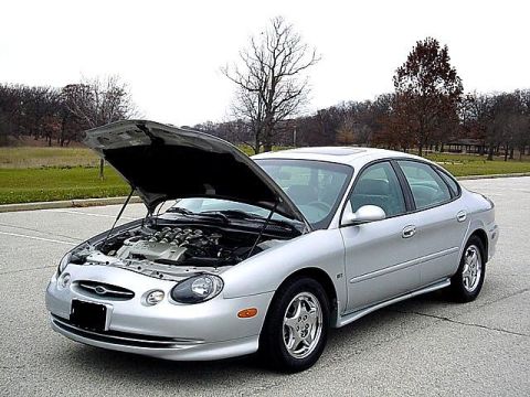 1998 Ford Taurus - Silver 1998 Ford Taurus sedan with the hood open, parked outdoors on pavement.