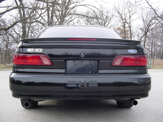 Black Ford Taurus SHO rear view with spoiler and dual exhaust pipes