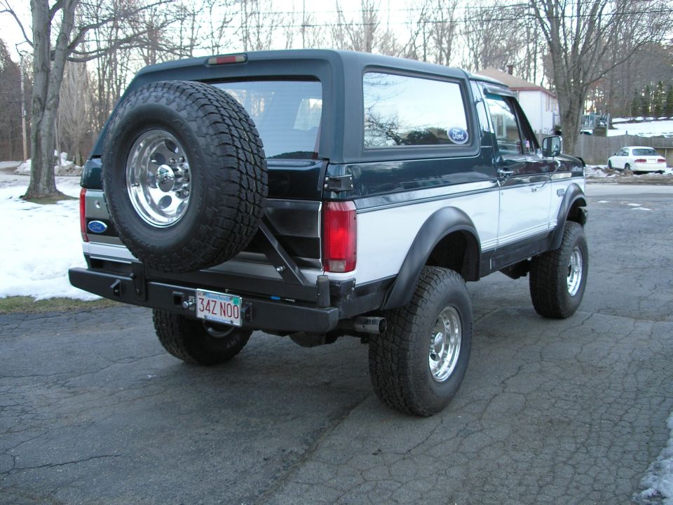 Ford Bronco with spare tire on back, aftermarket bumper, and lifted suspension