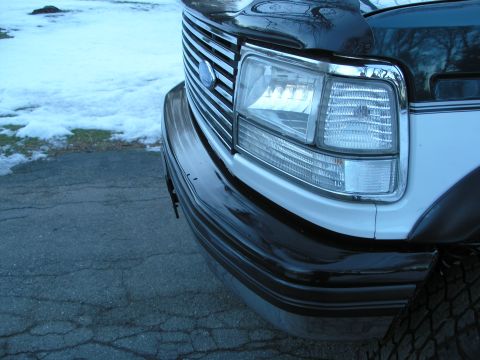 1994 Ford Bronco - Close-up of the front grille and headlight assembly on a 1994 Ford Bronco.