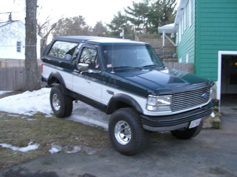 1994 Ford Bronco - This 1994 Ford Bronco features a two-tone dark green and white paint scheme and a prominent grille.