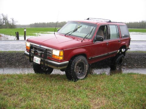 1991 Ford Explorer - 1991 Ford Explorer in a flooded field, equipped with a brush guard and large tires.