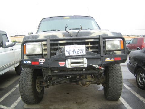 1990 Ford Bronco - close front view of a lifted camo truck displays its ARB brush guard, Warn winch and California plate 5CHW698.