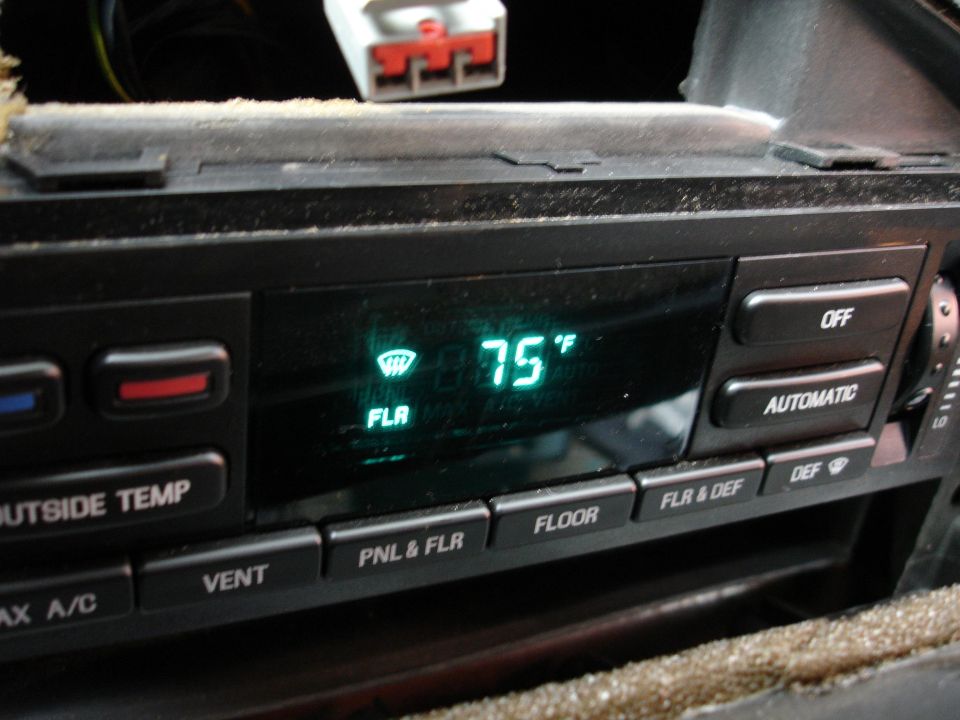 Close-up of a car's climate control panel showing 75 degrees Fahrenheit and various button labels like 'OFF', 'AUTOMATIC', 'FLOOR', and 'VENT'