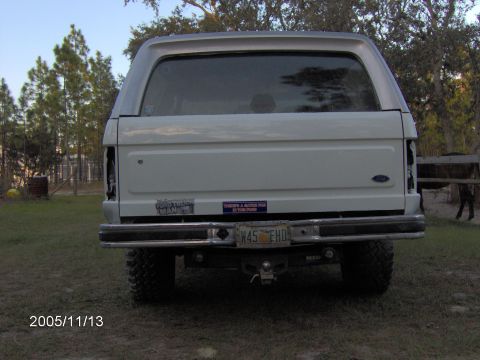 1983 Ford Bronco - Rear view of a white 1983 Ford Bronco, showing its license plate and bumper stickers.