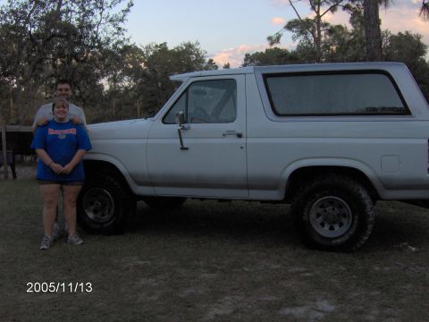 1983 Ford Bronco - Side view of a white 1983 Ford Bronco with two people standing beside it.