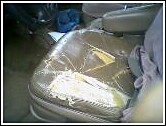 1993 Ford Bronco - A close-up view of a damaged car seat with visible repairs and wear.