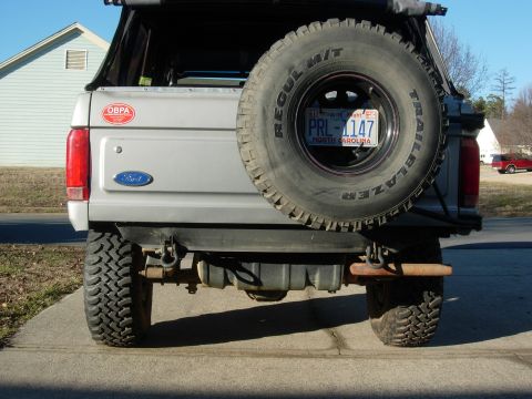 1995 Ford Bronco - The rear of a 1995 Ford Bronco shows a spare tire, a Ford emblem, and an OBPA sticker.
