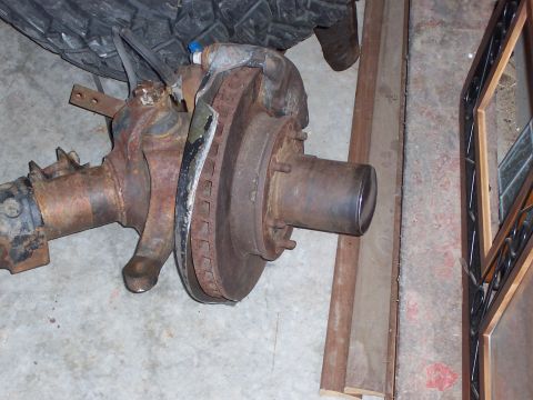 1991 Ford Bronco - Close-up of a heavily rusted front axle assembly, likely for a truck or SUV.