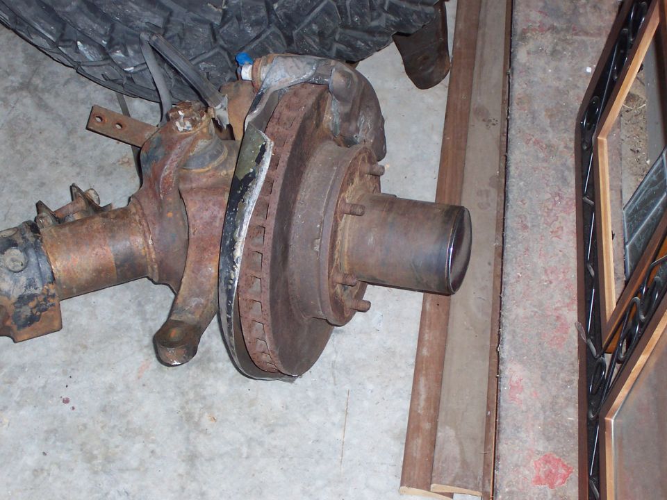 rusted front axle assembly with brake rotor and caliper bracket