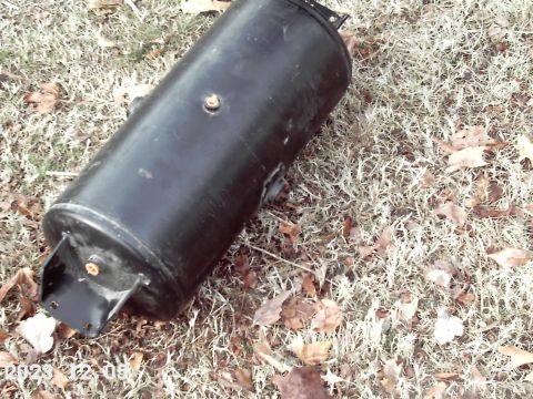 1988 Ford Bronco - Cylindrical tank with mounting brackets, likely an air or fuel tank, on the ground.