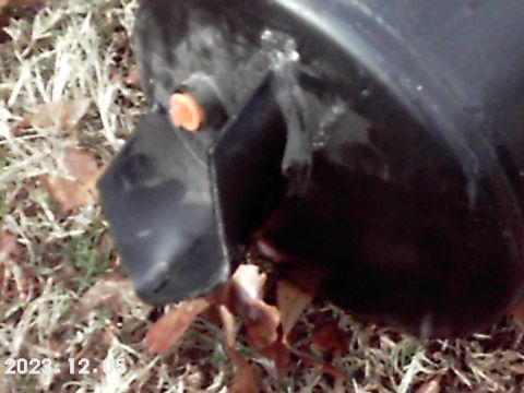 1988 Ford Bronco - A close-up view of a black plastic bumper component with an orange plastic insert and visible adhesive.