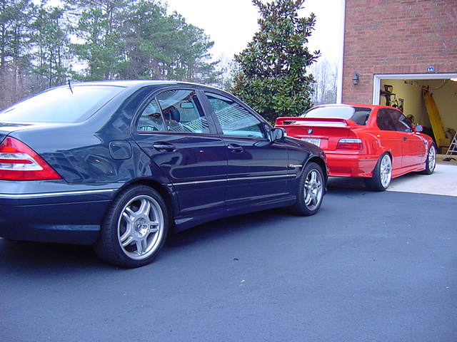 Dark blue Mercedes-Benz C-Class sedan rear three-quarter view in a driveway