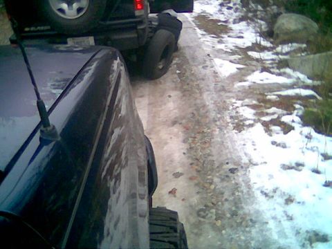 1976 GMC C/K Pickup - Two vehicles are on a snowy and icy road, suggesting winter conditions.
