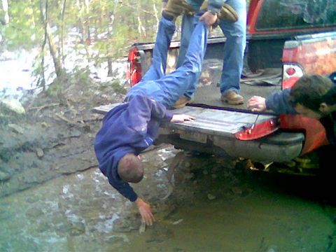 1976 GMC C/K Pickup - Friends help pull a person out of a muddy ditch next to a pickup truck.