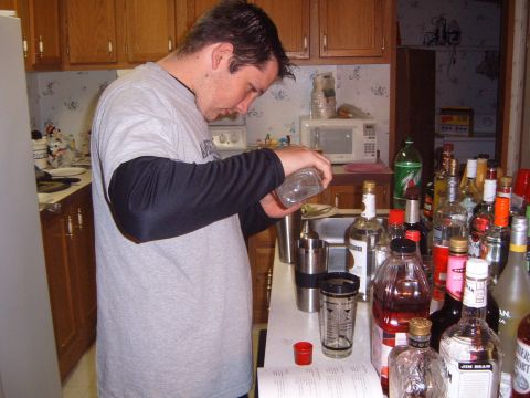 1988 Ford Bronco - A man is preparing drinks in a kitchen filled with various bottles of liquor.
