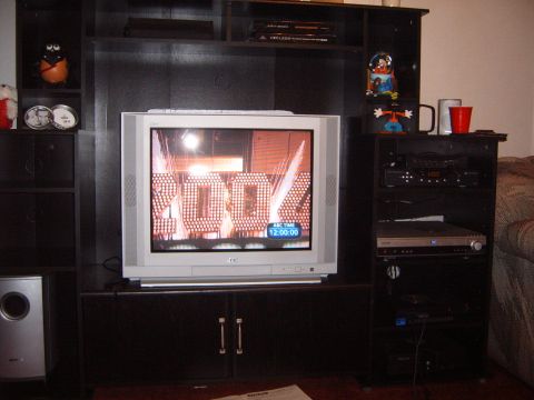 1988 Ford Bronco - A television displays a graphic with the text "100%" and the time, set within a dark entertainment center.