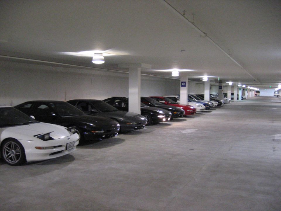 Row of parked sports cars in an underground concrete parking garage