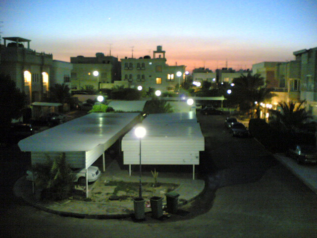 Residential buildings and parked cars at dusk with a colorful sky
