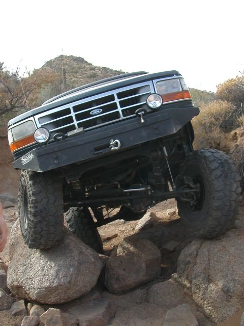 1984 Ford Bronco - Ford Bronco navigating a rocky trail, showing off its off-road capabilities.