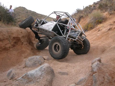 1984 Ford Bronco - This custom buggy navigates a challenging off-road course, demonstrating its extreme suspension capabilities.