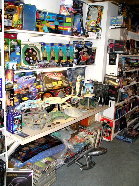Shelves crowded with Star Trek toys, models, board games and collectibles; no vehicle shown.