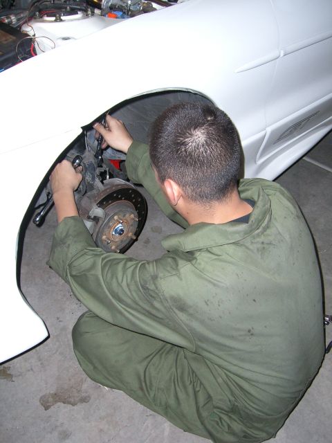 1996 Ford Probe - Mechanic works on the brake caliper of a 1996 Ford Probe.