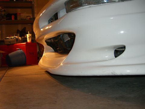 1996 Ford Probe - The front of a white vehicle is shown in a garage setting, with storage items visible behind it.