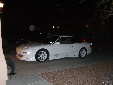 1996 Ford Probe - A white 1996 Ford Probe GT is parked in a driveway at night, with a spare tire visible in the foreground.