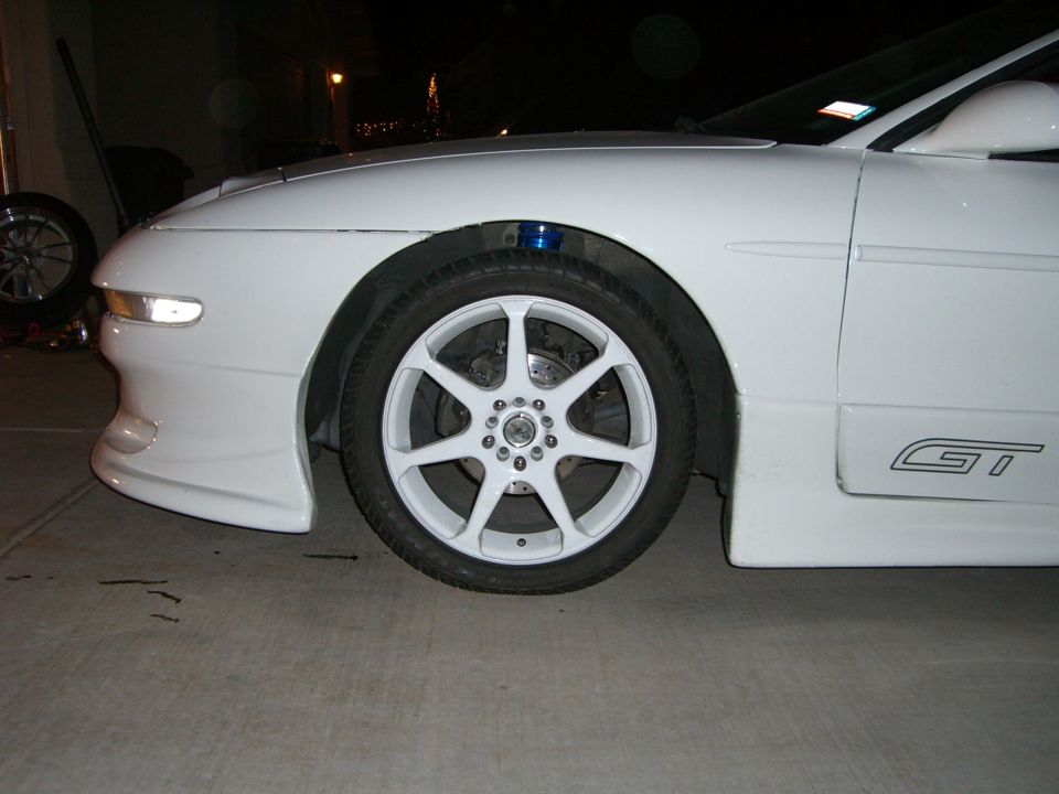 White car front fender and wheel with GT badging on the side skirt