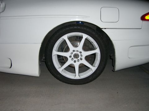 1996 Ford Probe - The rear wheel of a white 1996 Ford Probe features aftermarket white rims.