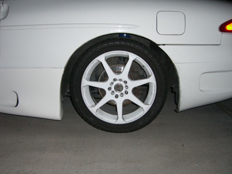 White 1996 Ford Probe rear wheel with aftermarket white rims