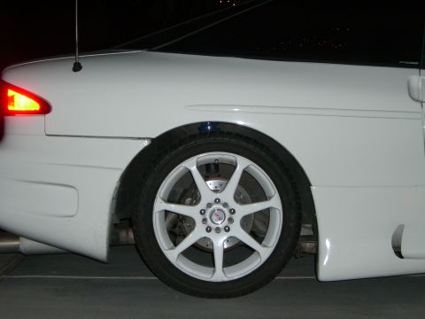 1996 Ford Probe - A white coupe is shown from the side, focusing on the rear wheel and fender area at night.