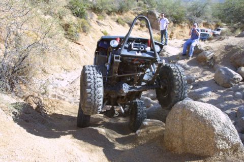 1994 Ford Bronco - Custom off-road buggy tackles a challenging rocky obstacle on a desert trail.