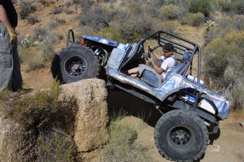 1994 Ford Bronco - This heavily modified buggy is navigating a challenging rocky terrain, its off-road capabilities.
