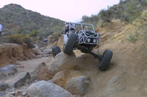 1994 Ford Bronco - A custom-built buggy navigates a challenging rocky trail in a desert landscape.
