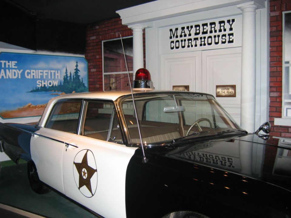 Replica police car from The Andy Griffith Show with 'Mayberry Courthouse' sign