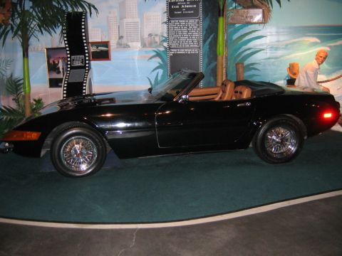 1985 Ford LTD Crown Victoria - A black convertible sports car with tan interior is displayed indoors, possibly in a museum or exhibit.