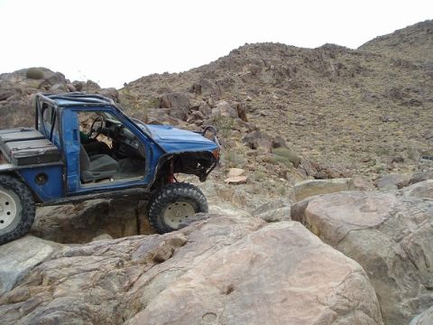 1989 Ford Bronco - Modified pickup truck navigating a rocky, off-road trail.
