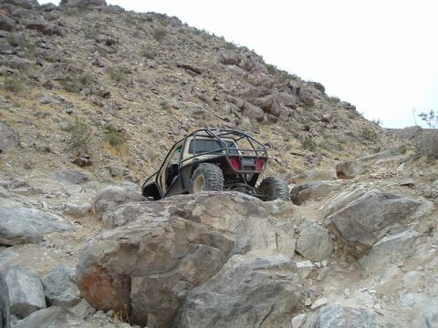 1989 Ford Bronco - This off-road vehicle navigates a challenging rocky path on a steep incline.