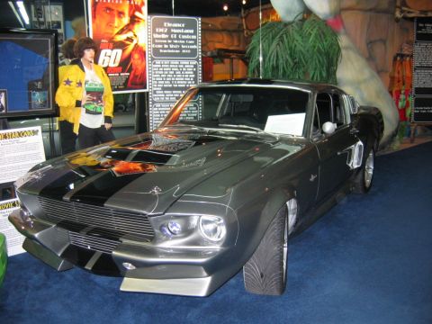 1985 Ford LTD Crown Victoria - A custom 1967 Shelby GT500, known as 'Eleanor', is displayed indoors with movie memorabilia.